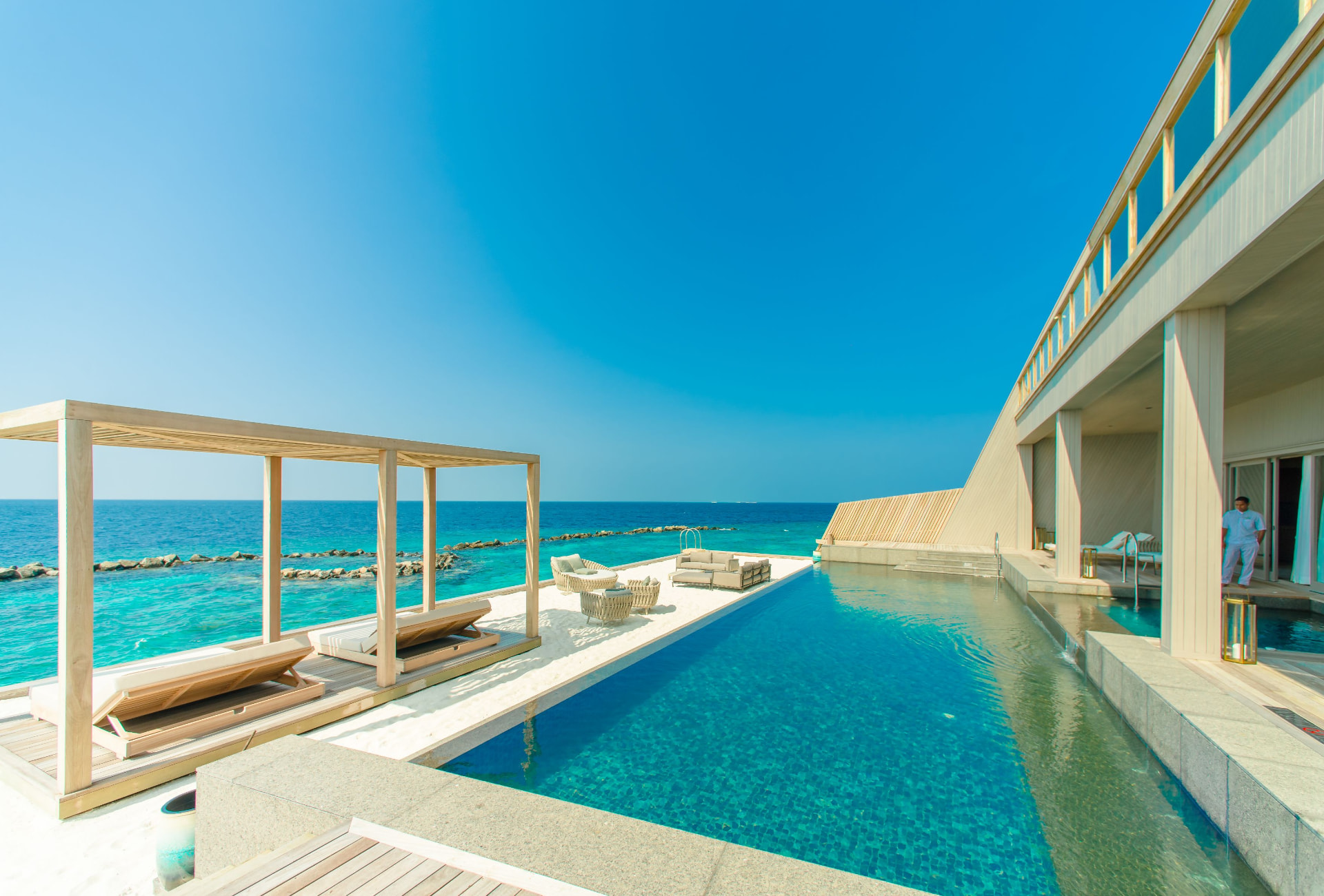 An infinity pool beside a luxury villa overlooking the sea